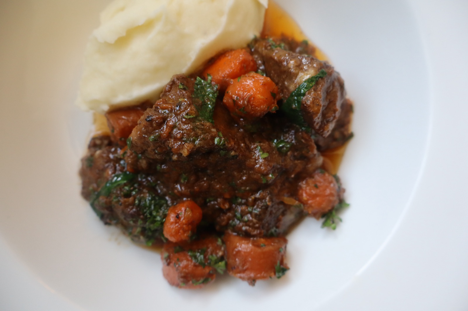 Braised beef brisket with carrots and gremolata beside silky Paris mash
