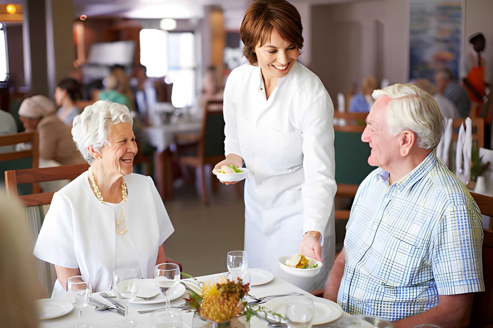Aged-care staff serving meal to seated residents